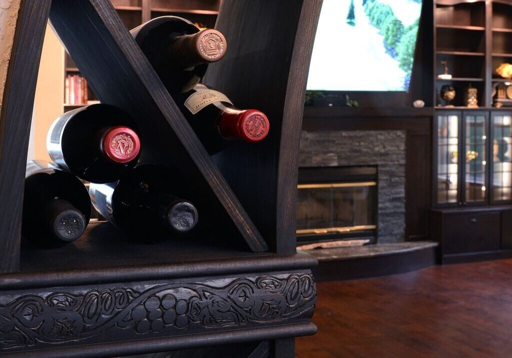 Wine bottles on decorative wooden rack.